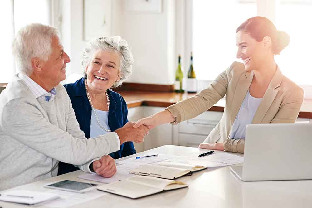 Couple shaking hands with a Medicare agent